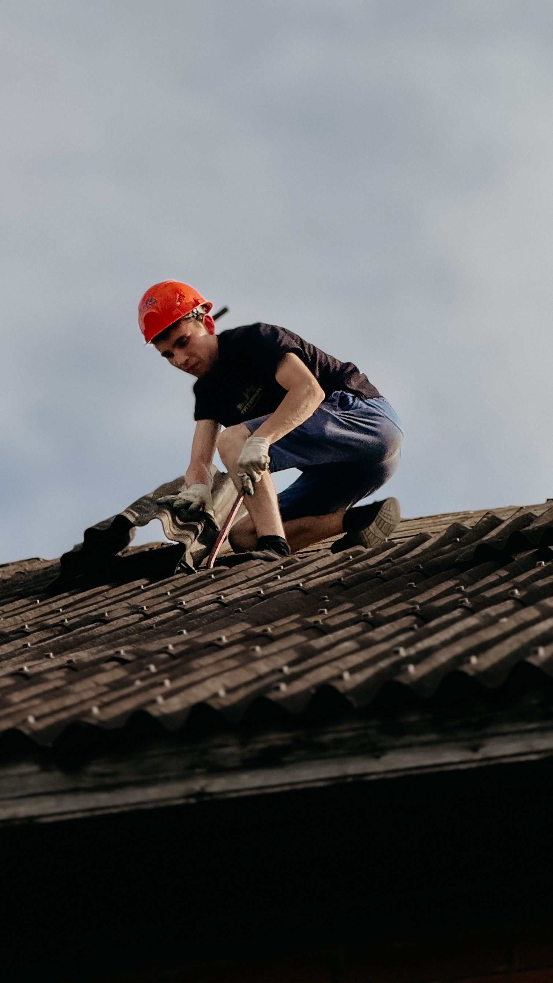 Roofing professional inspecting and repairing a roof